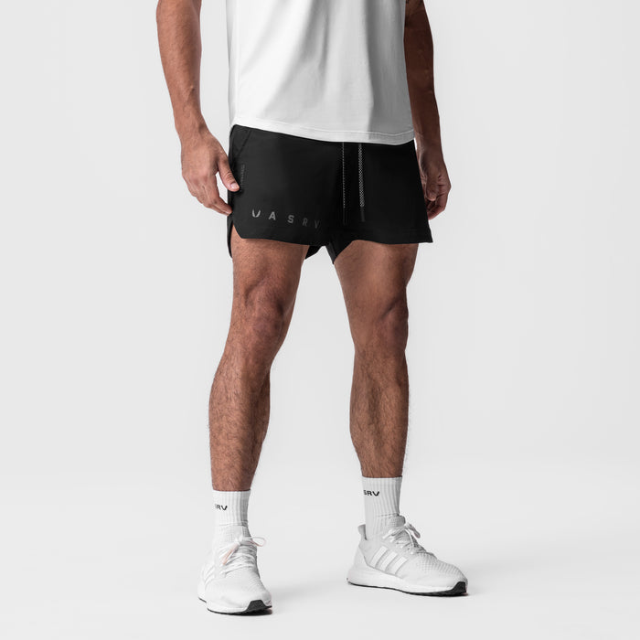 Tetra-Lite 5" Linerless Short in black with reflective branding, worn with white socks and sneakers