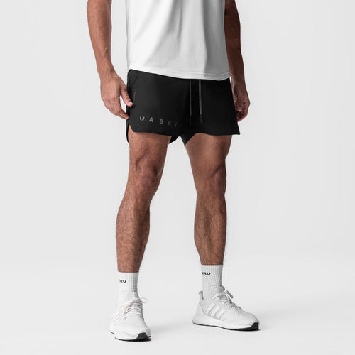Tetra-Lite 5" Linerless Short in black with reflective branding, worn with white socks and sneakers