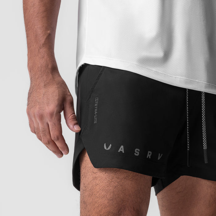 Tetra-Lite 5" Linerless Short in black with reflective logo, worn by model, side view