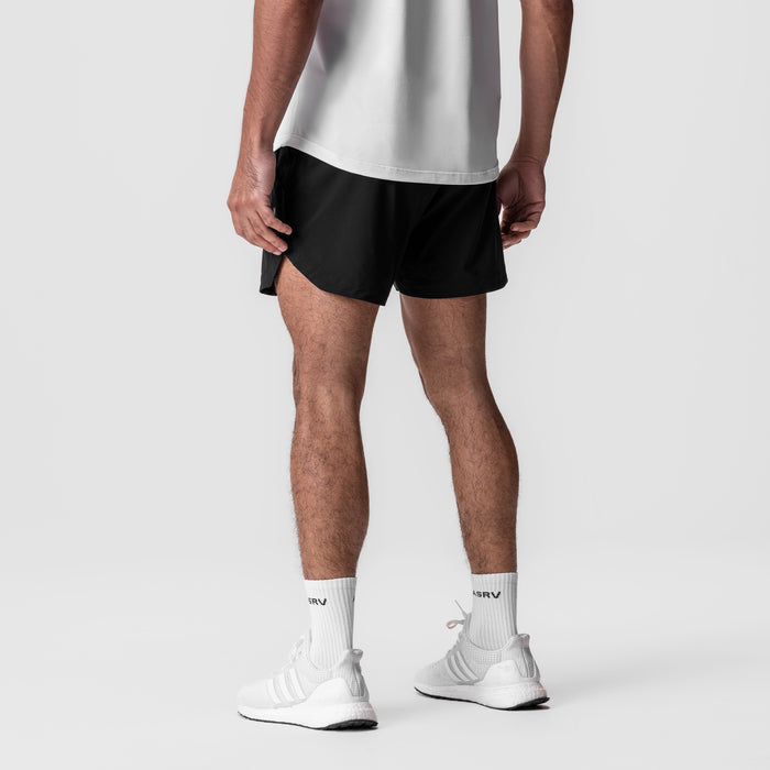 Tetra-Lite 5" Linerless Short in black, worn with white socks and sneakers, rear view