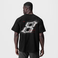 Black Tech Essential Relaxed Tee with blurred graphic design, back view on model