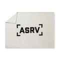 flatlay Sherpa Recovery Blanket in ivory cream with black ASRV logo, folded corner view