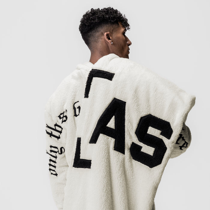 Sherpa Recovery Blanket in ivory cream with black lettering, worn by model showing back view
