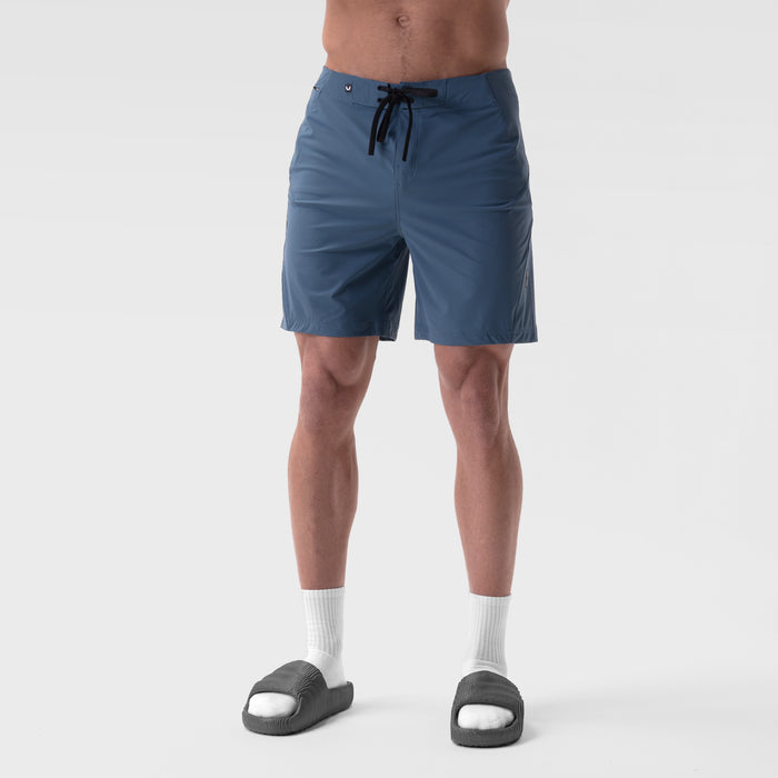Revolutional Board Short in storm blue, worn by model with white socks and dark slides, front view