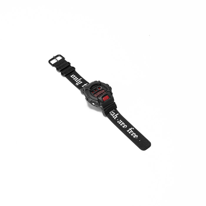 flatlay of ASRV x G-SHOCK DW6900 digital watch in black with red accents, angled view