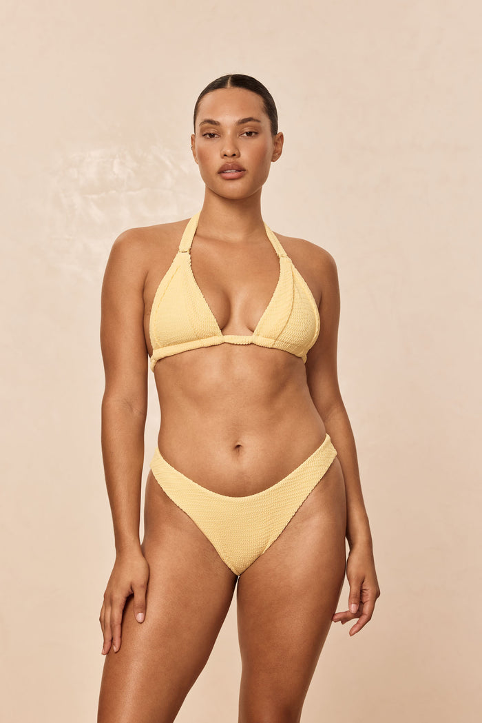 Front view of Byron Bottom in Honey Crinkle, crinkle texture, medium-rise high-cut leg on model against beige background