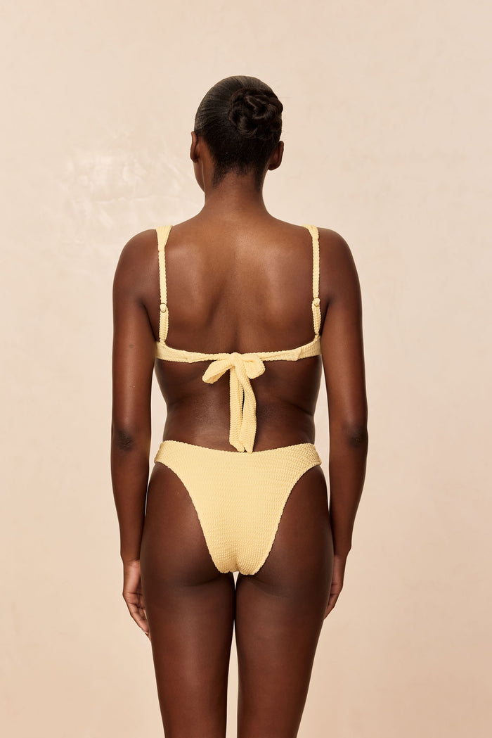 Back view of Byron Bottom in Honey Crinkle showcasing high-cut leg and textured crinkle fabric on a neutral beige background