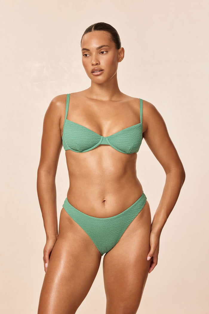 Front view of Byron Bottom in Pond Crinkle on model showing high‑leg cut and textured crinkle fabric, beige background