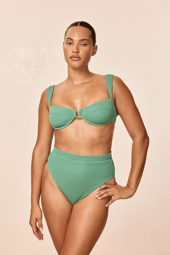 Front view of Cala Roja top in Pond Crinkle green on model showing underwire balconette shape, wide straps, crinkled texture