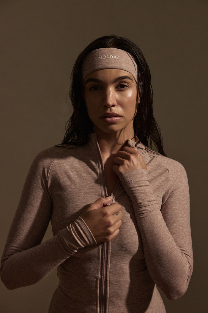 Close up of Cambria Jacket in heather mauve on model showing zip, thumbholes and matching MONDAY headband
