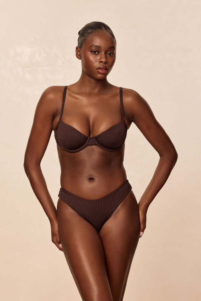 Front view of Capri Top in Espresso Wide Rib on model showcasing enhanced underwire cups, ribbed texture and adjustable straps with beige background