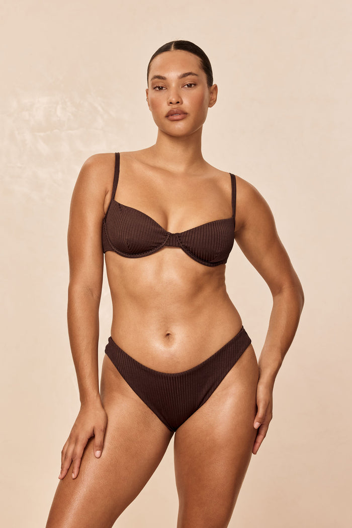 Model wearing Capri Top in Espresso Wide Rib showing underwire cups, adjustable straps and ribbed texture on beige background