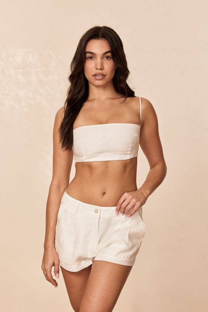 Front view of Casablanca Short in white linen on model showing pleats, side pockets, and button-and-zip closure