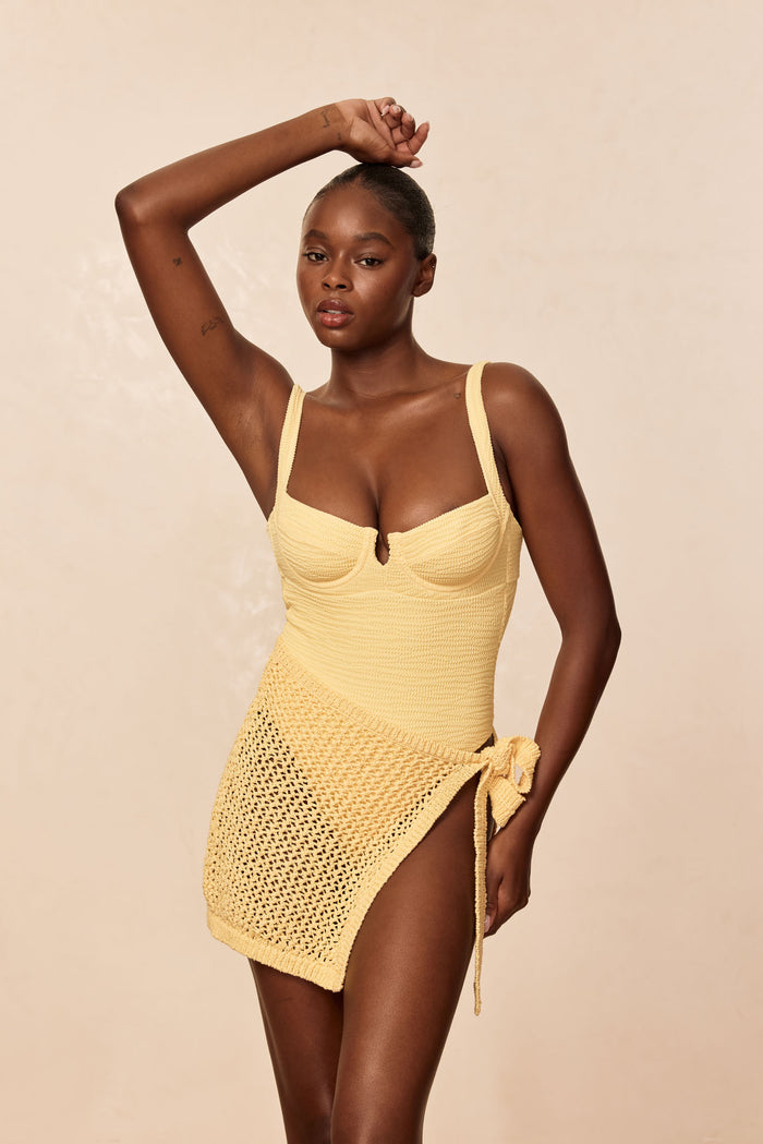 Front view of Clovelly One Piece in honey crinkle showing underwire sweetheart bust, wide straps, textured knit on beige background