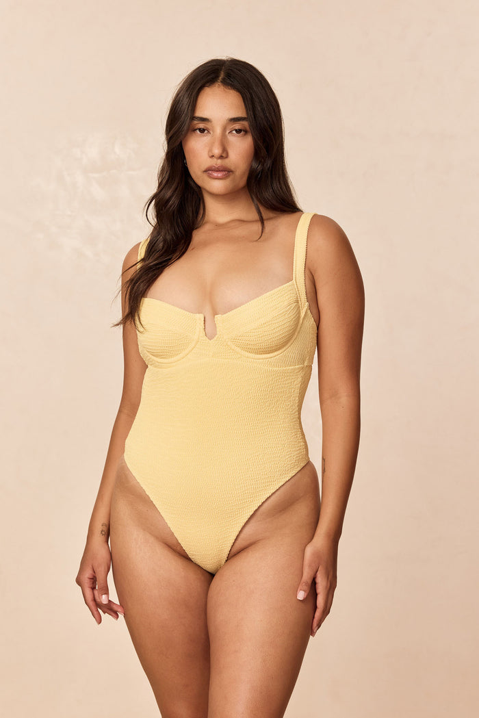 Front view of Clovelly One Piece in Honey Crinkle with underwire cups, crinkle texture, and high-cut leg on beige background