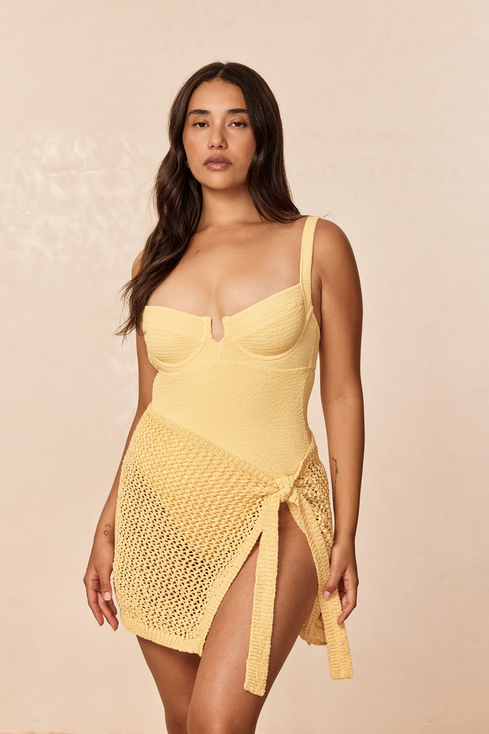 Front of Clovelly one-piece in Honey showing underwire sweetheart bust, textured knit, tied crochet wrap on beige backdrop