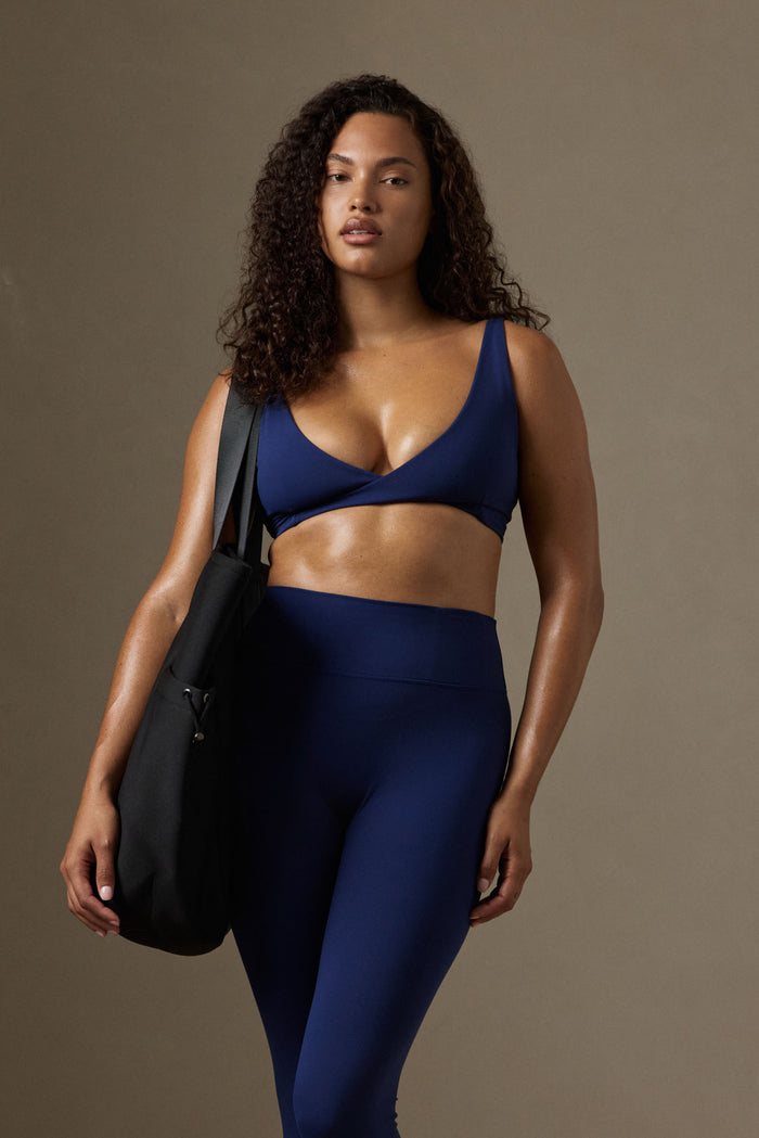 Front view of Monday Body Tote Bag in black on model’s shoulder showing oversized neoprene body against neutral background