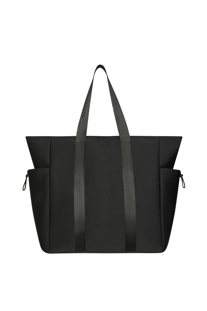 Front view of Monday Body Tote Bag showing black neoprene body, long webbed shoulder straps, and side draw-cord pockets on white background