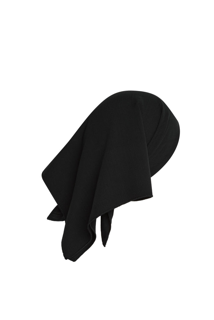 Angled view of Monday Headscarf in black showing square shape and soft rayon drape on white background