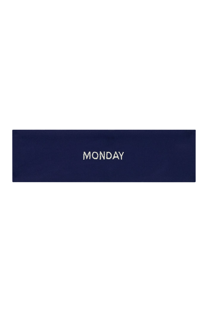 Flat lay of Monday Headband in midnight navy showing centered white "MONDAY" embroidery on a white background