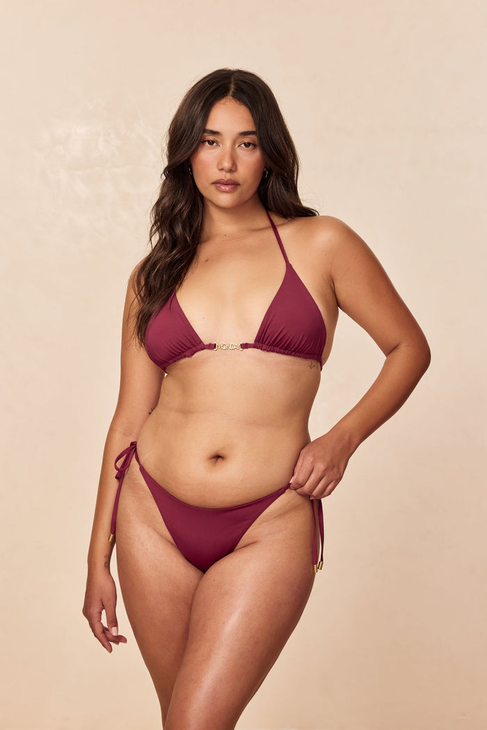Front view of Palma Bottom in Fig showcasing tie-side strings with gold tips on a neutral beige background