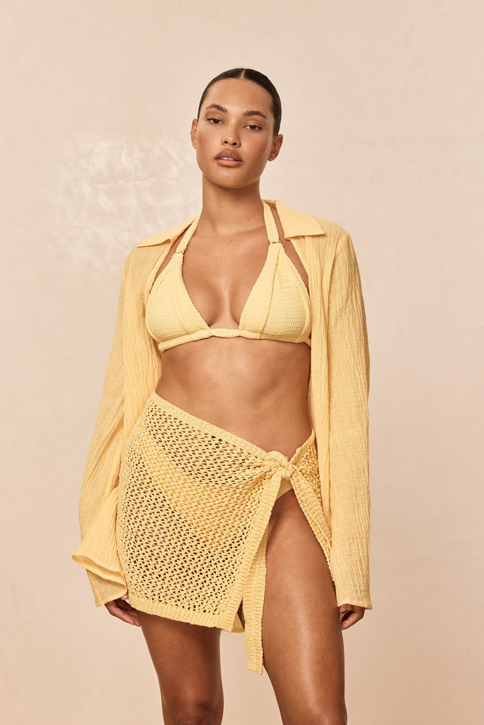 Front view of Morocco Top in Honey Crinkle showing textured crinkle triangle cups and halter straps on model against a beige background