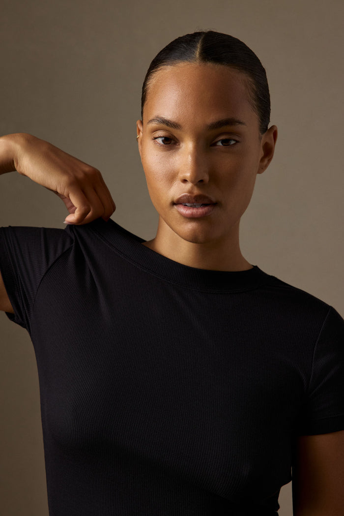 Close-up of Ojai Tee Long black rib tee showing crew neck, short sleeves and ribbed texture on model against neutral backdrop