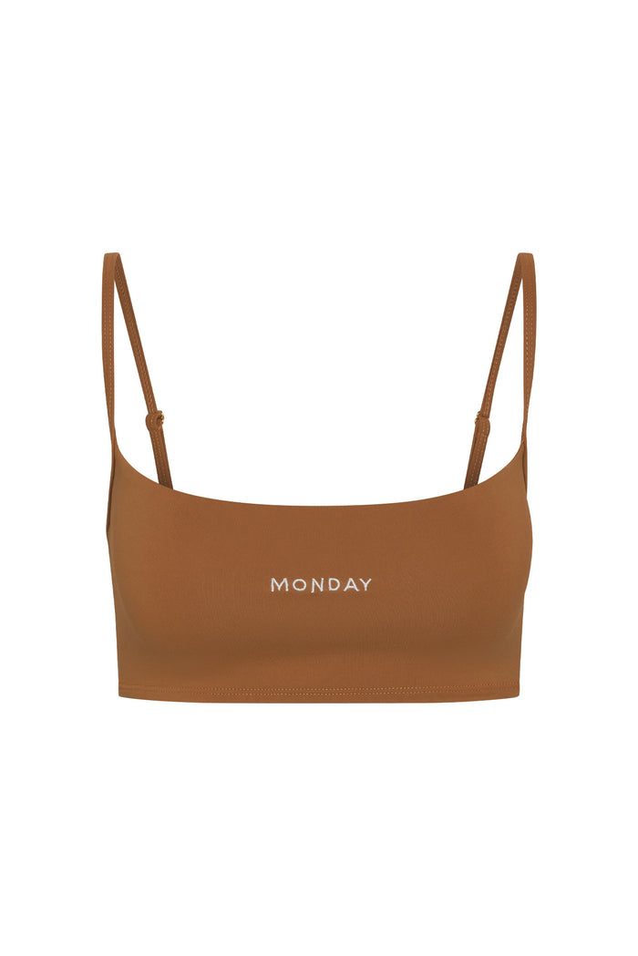 Front view of Olympic Bra in caramel showcasing scoop neckline, adjustable straps, embroidered MONDAY logo on white