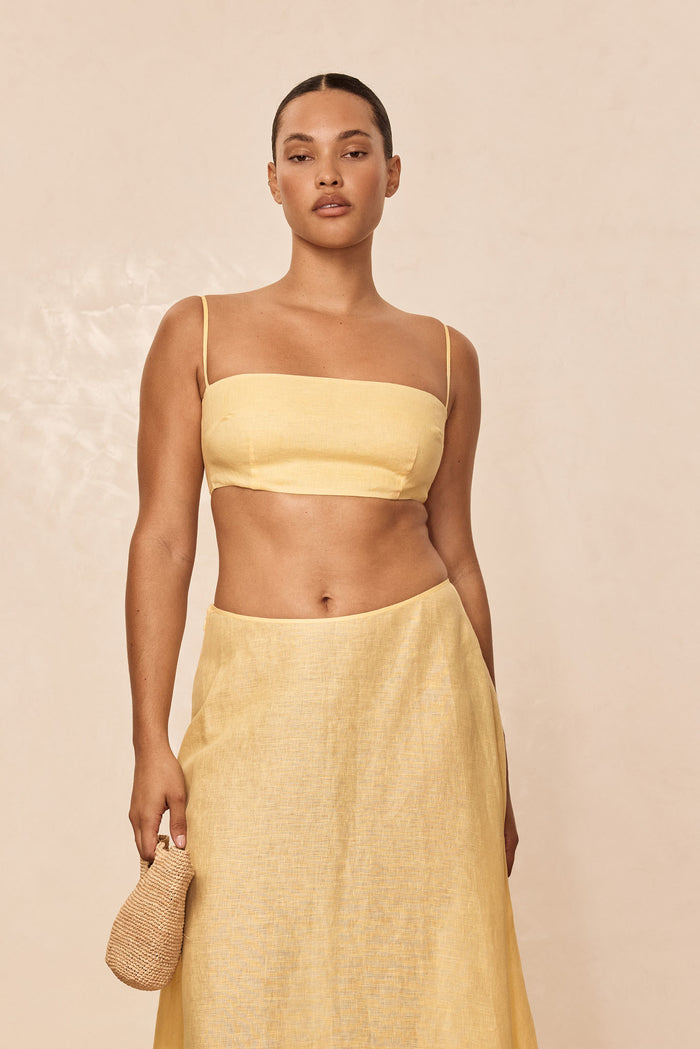 Front view of San Diego Top in Honey, cropped linen bandeau with adjustable straps and back tie against beige background