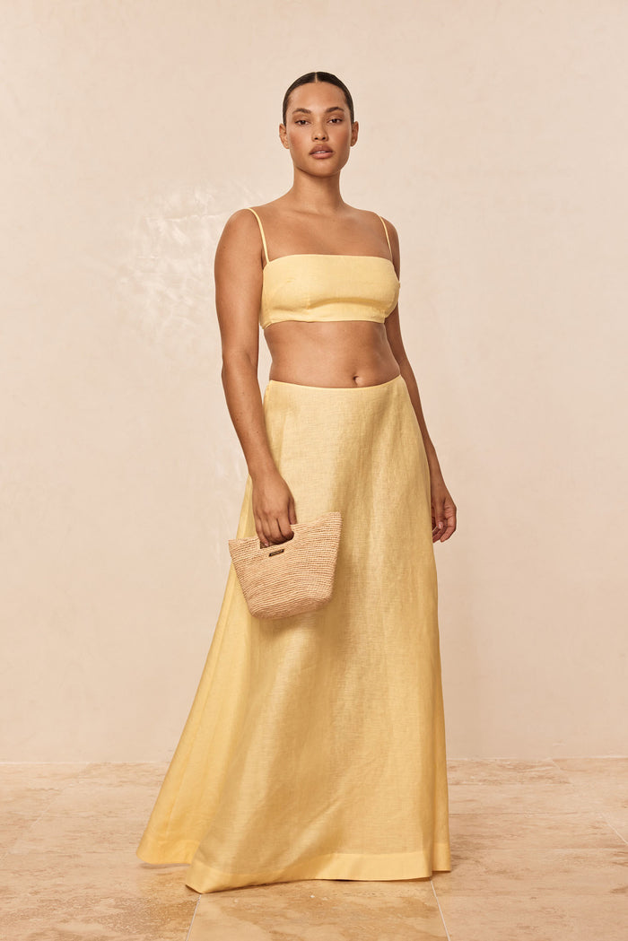 Front view of San Diego Top in Honey on model showcasing cropped linen tank with thin adjustable straps and straight neckline on neutral beige background