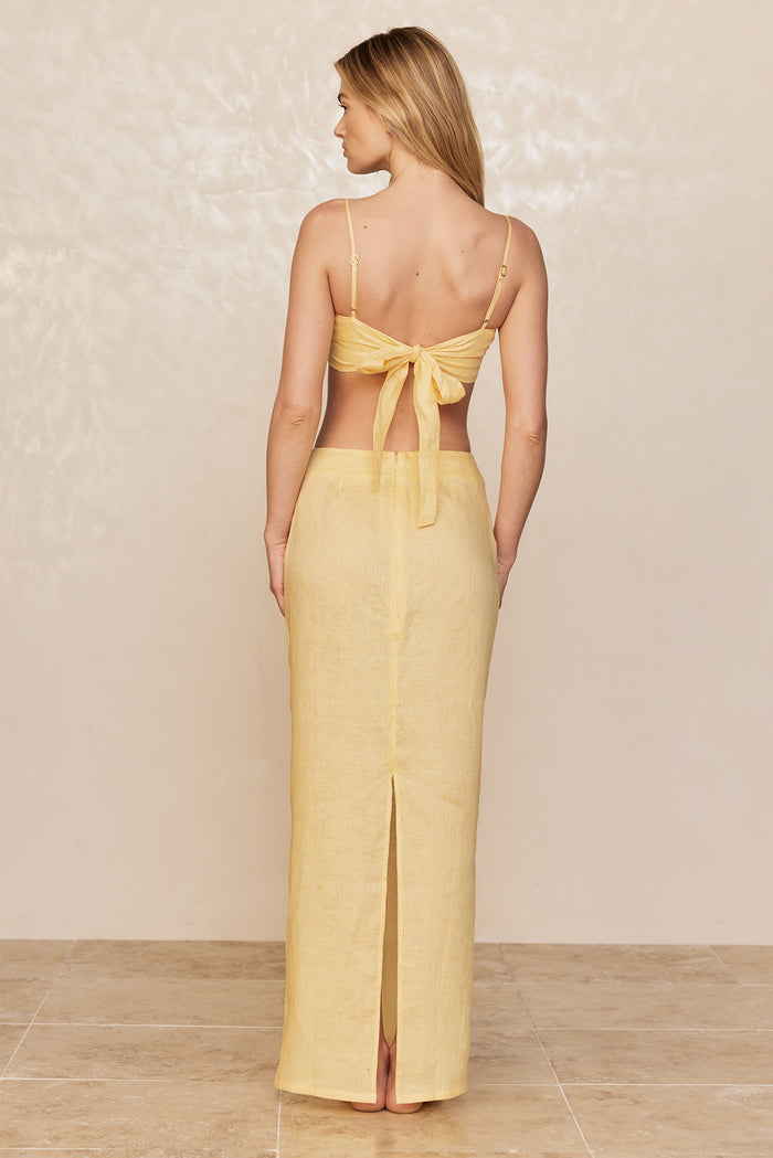 Back view of San Diego Top in Honey on model showcasing tie-back closure and adjustable thin straps on beige background