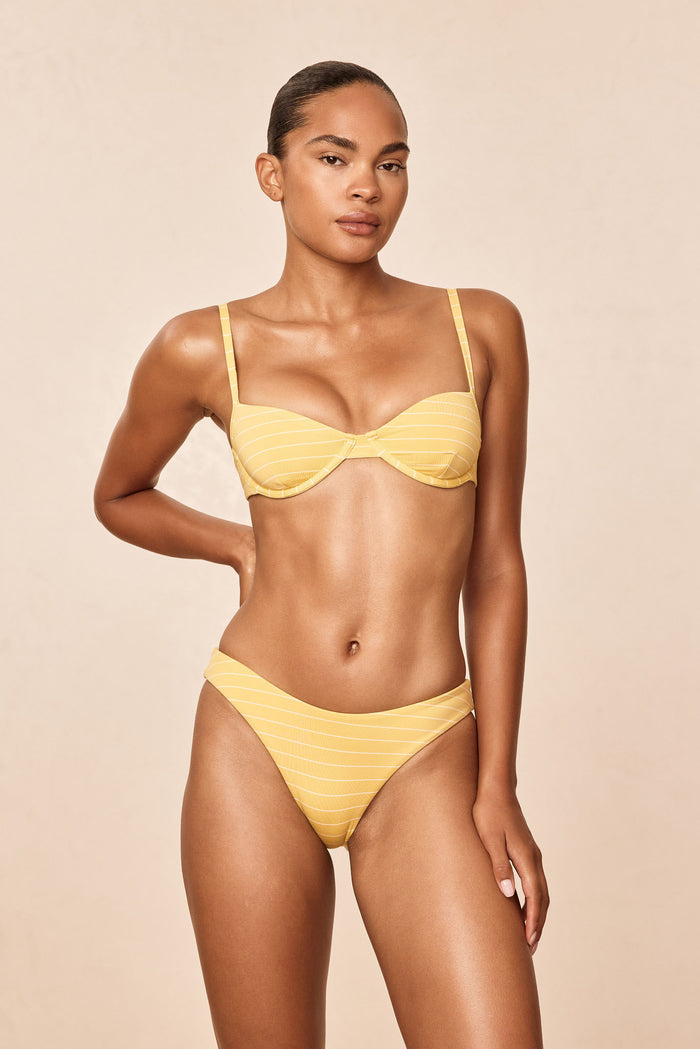 Front view of Seychelles Bottom - Meyer Stripe showing mid-rise moderate coverage in yellow Meyer stripe on a model against a beige studio background