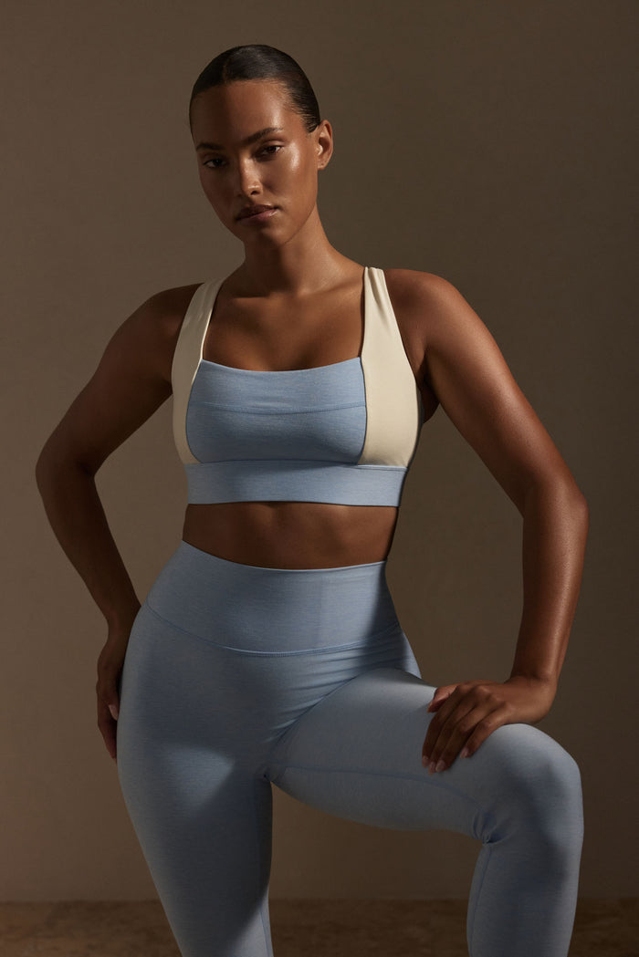 Front view of Tash Bra in Heather Sky and Ivory on model showcasing square neckline, colorblocked panels and thick adjustable underbust band