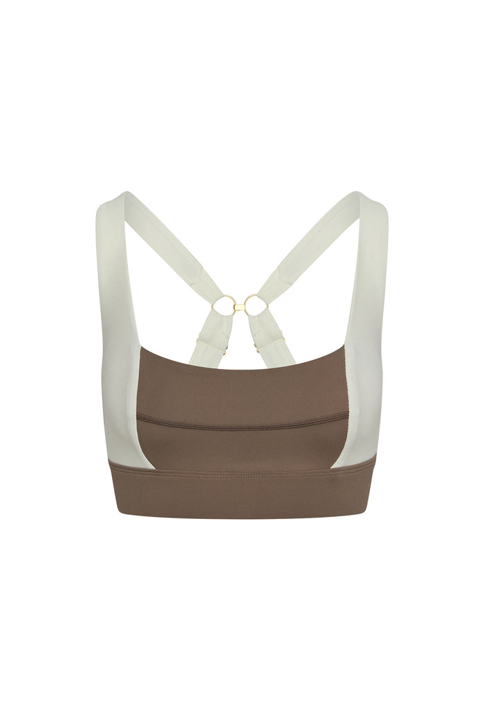 Back view of Tash Bra in stone and ivory jersey showcasing cross-back straps and gold ring hardware on white background