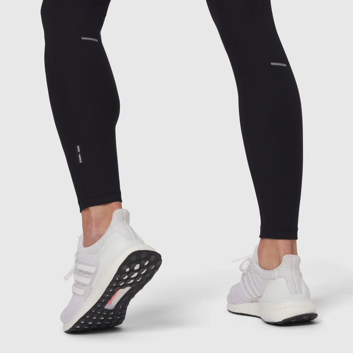 Black Lycra ribbed running tight worn with white sneakers, lower body view