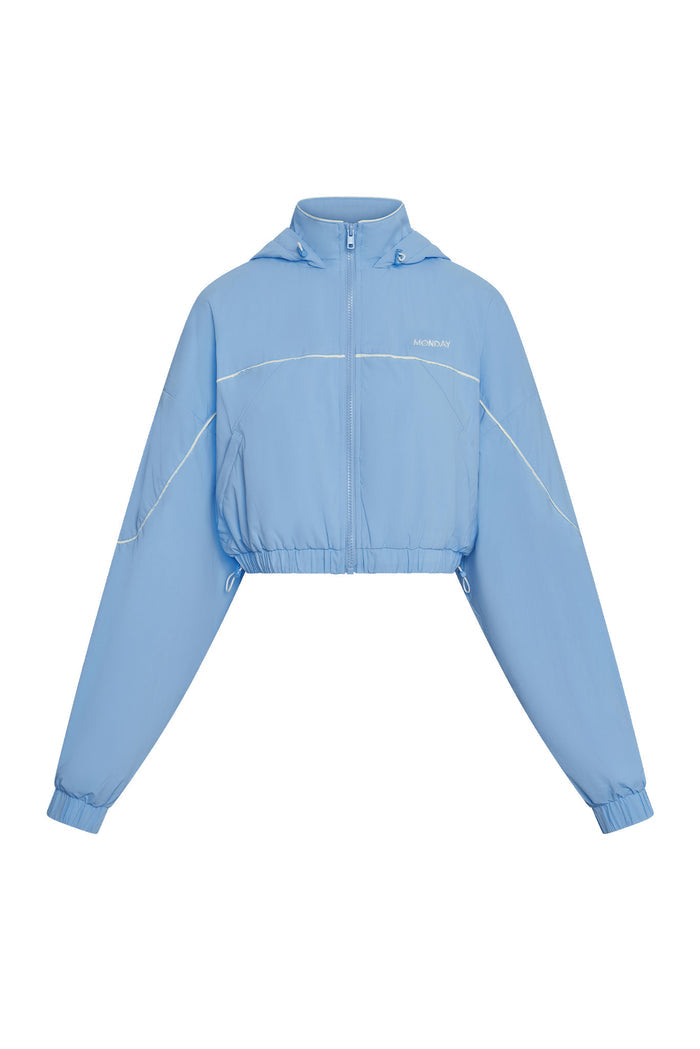 Front view of Westmount Jacket in Sky Nylon showcasing cropped fit, zip front, hood, elastic cinch hem on white background