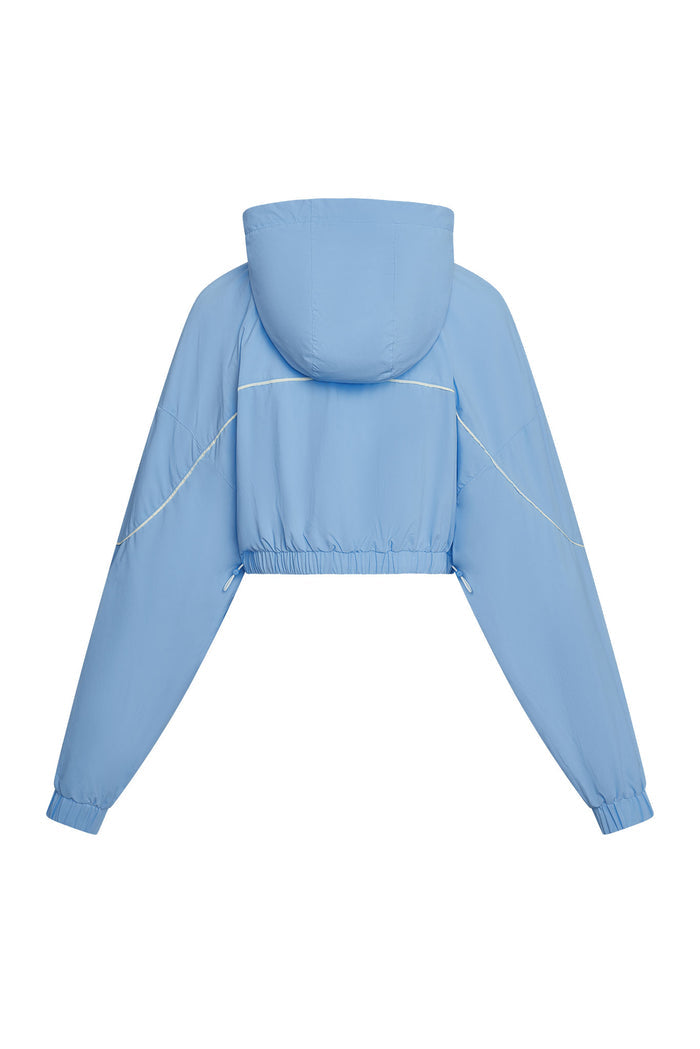 Back view of Westmount Jacket in Sky Nylon showing cropped fit, hood, elastic bungee hem and contrast piping on white