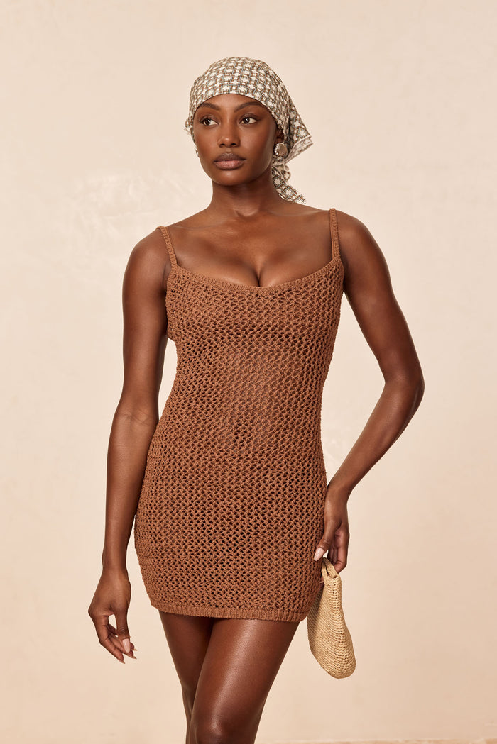 Front view of Zanzibar Dress in caramel crochet, sheer open-knit fabric, slim straps, V-neckline on beige background