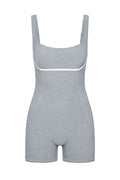 Light-gray shaping bodysuit with shorts, adjustable straps and white piping under the bust.