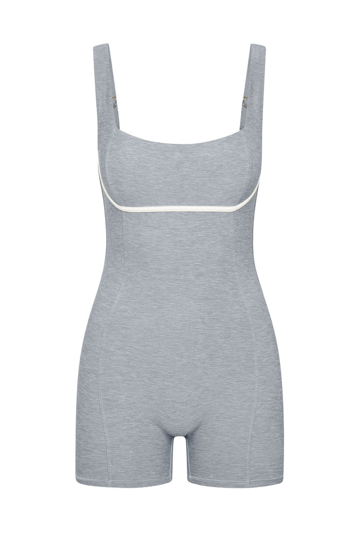 Light-gray shaping bodysuit with shorts, adjustable straps and white piping under the bust.