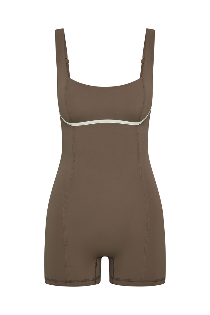 Front view of Zion Romper in stone with ivory underbust trim, square neckline and short biker style legs on white background