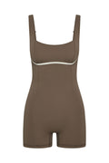 Front view of Zion Romper in stone with ivory underbust trim, square neckline and short biker style legs on white background